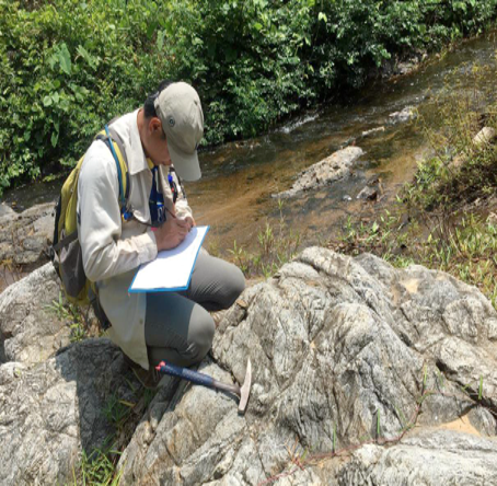 Geologist taking notes by a stream